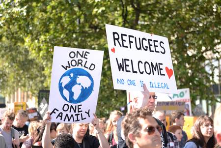Demonstranten mit "Refugees Wellcome" Plakat und anderen